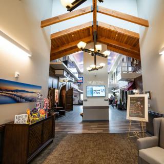 A modern lobby with wooden beams, a chandelier, and comfortable seating.