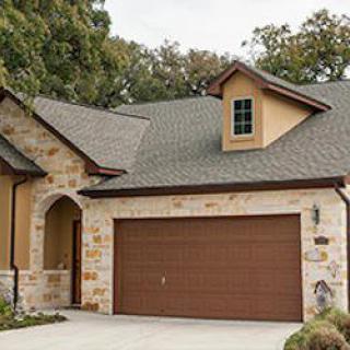 A modern house with a stone exterior and a double garage.