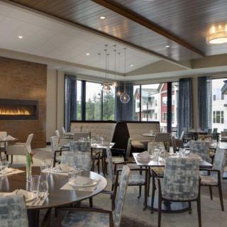 A modern, elegantly designed restaurant interior with tables and chairs set up for dining.