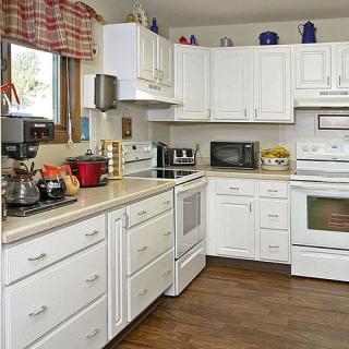 A cozy kitchen featuring white cabinets and modern appliances.
