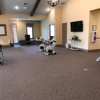 A spacious and well-equipped fitness center featuring exercise machines and a comfortable atmosphere.