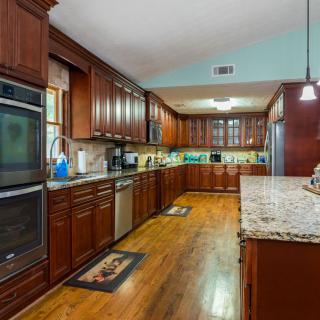 Spacious modern kitchen with wooden cabinets and granite countertops.