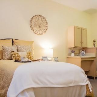 A cozy and well-decorated bedroom with soft lighting and neutral tones.