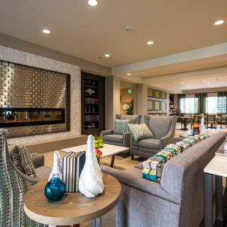 A modern and stylish living room with comfortable seating and a fireplace.