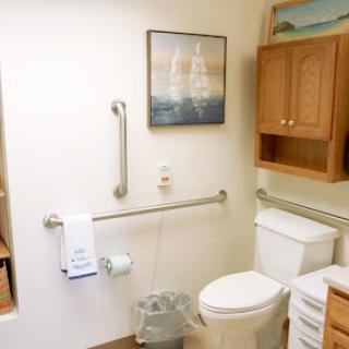 A clean and organized bathroom featuring essential fixtures and some decorative artwork.
