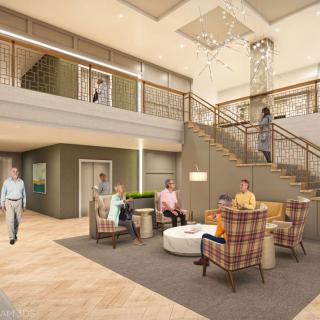 A modern lobby with a seating area and staircase, occupied by several people engaging in conversation.