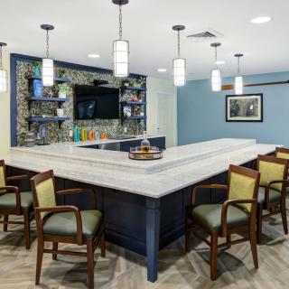 A modern kitchen bar area with stylish lighting and seating.