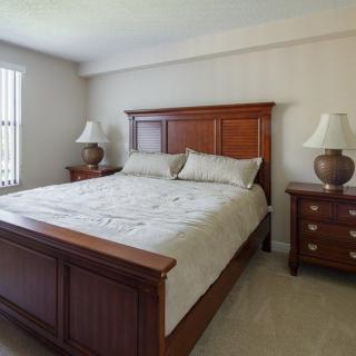 A well-furnished bedroom with a large bed, two nightstands, and lamps.