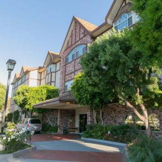 A picturesque hotel with Tudor-style architecture surrounded by trees.