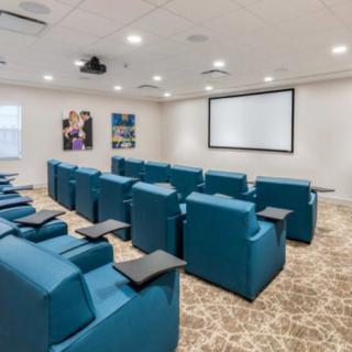 A home theater room with comfortable seating and a large screen for viewing.