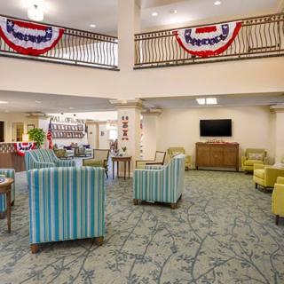 A spacious lobby with comfortable seating and patriotic decorations.
