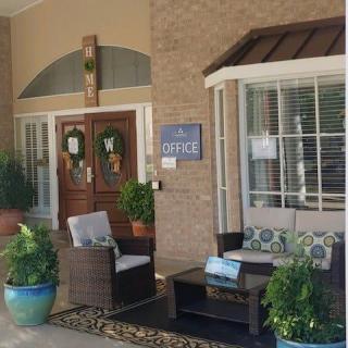 A welcoming building entrance with seating and plants.