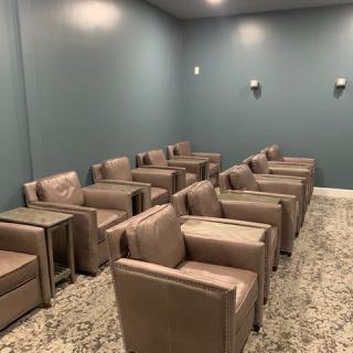 A neatly arranged waiting area with rows of armchairs and side tables.
