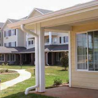 A view of residential buildings with a walkway and garden area.