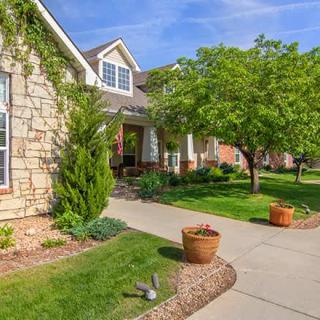 A well-maintained suburban house with a landscaped front yard and driveway.