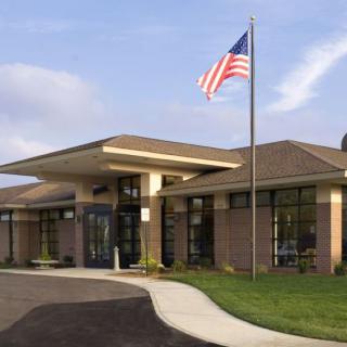 A school building with an American flag at the entrance during daytime.