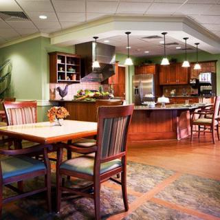 A cozy kitchen and dining area with warm lighting and wooden furniture.