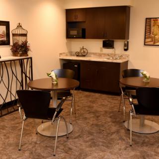 A modern kitchenette with seating area featuring tables and chairs.