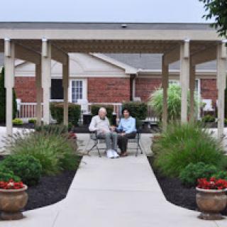 Two seniors enjoying a peaceful afternoon in a community outdoor space.