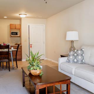 A cozy apartment featuring a comfortable living room with a dining area and modern furnishings.