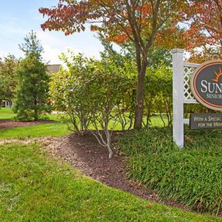 A scenic view of a landscaped area with a sign and lush greenery.