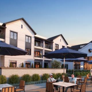 A modern hotel with outdoor seating and a sunny atmosphere, perfect for relaxation.