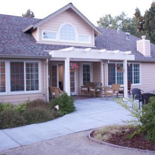 A charming residential house with a welcoming porch and well-maintained landscaping.