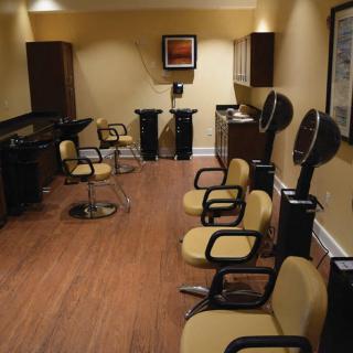 An empty hair salon with styling chairs and equipment.