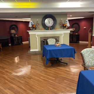 A cozy living space featuring blue tables and a decorative fireplace.