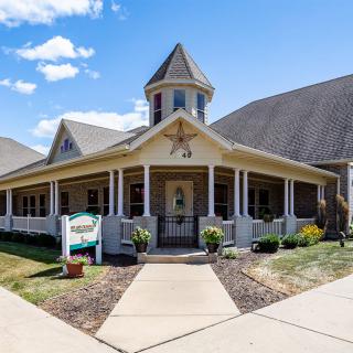 A picturesque building with a pointed roof and porch, set against a clear blue sky.