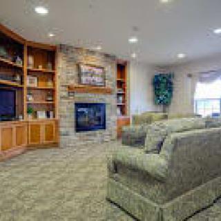 A cozy living room with a stone fireplace and comfortable seating.