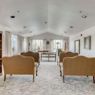 A serene chapel interior with rows of wicker seating and ample natural light.