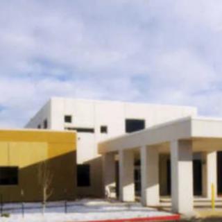 A modern building with columns under a cloudy sky.