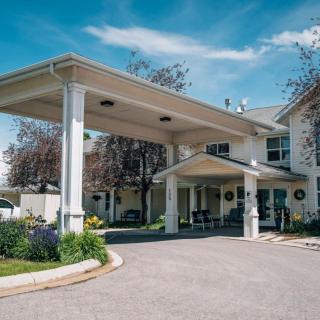A residential building with a covered entrance and landscaped surroundings.