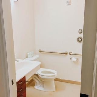 A clean and accessible bathroom with a toilet and sink.