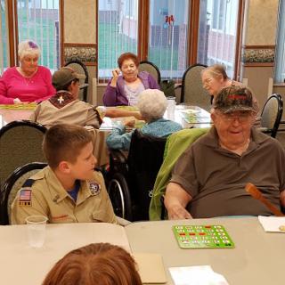 A heartwarming moment at a community bingo event, featuring children and elderly participants enjoying time together.