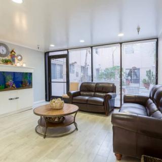 A modern living room with leather sofas, a round coffee table, and a wall-mounted television.