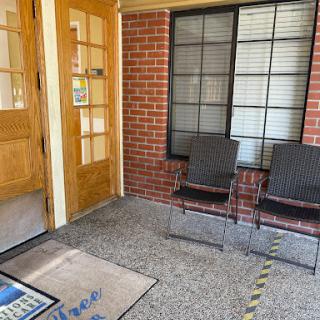 A welcoming entrance area featuring two chairs and a doormat.