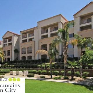 A sunny view of a modern apartment complex with palm trees and well-maintained landscaping.