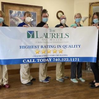 Healthcare team proudly showcasing their highest quality rating banner.