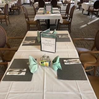 A neatly set dining table in a restaurant with menus and napkins arranged.