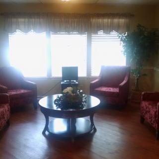 A cozy living room with red chairs and a central coffee table.