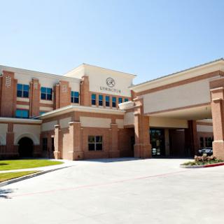 A well-lit hospital building showcasing modern architecture and accessible entry.