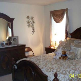 A cozy and well-decorated bedroom with a bed, dresser, and mirror.