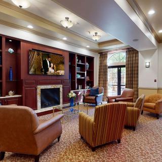 A cozy and well-decorated living room with comfortable seating, a fireplace, and a large television.