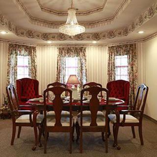 A traditional dining room with elegant furniture and a chandelier.