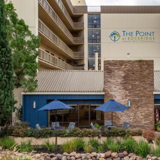 The Point Hotel features outdoor seating with umbrellas amidst well-maintained landscaping.