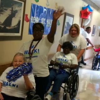 A group of people celebrating indoors, with some participants in wheelchairs.