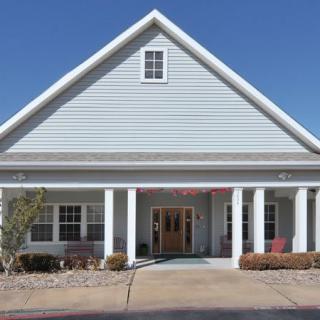 Front view of a residential style building with a gable roof and columns.