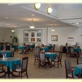 A spacious dining area with tables and chairs, featuring soft lighting and a comfortable atmosphere.